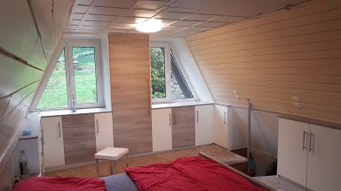 Einbauschränke Helle, moderne Dachzimmer mit zwei Fenstern und minimalistischem Mobiliar.
